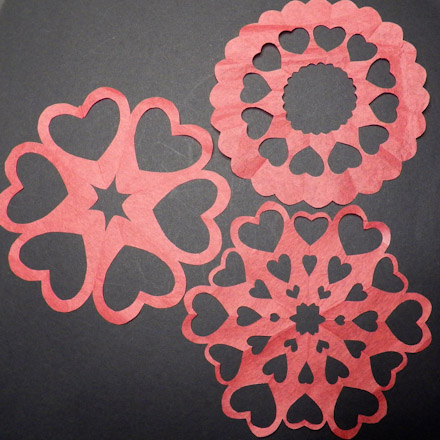 Heart snowflakes cut from red paper