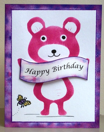 Card featuring a stenciled teddy bear holding a banner.